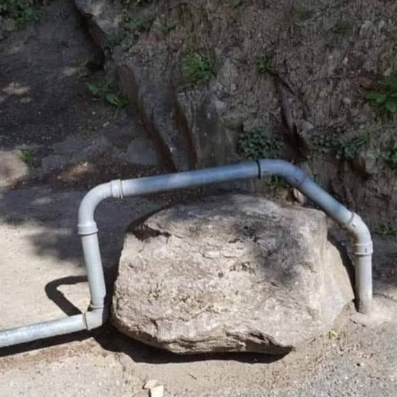 A picturre showing pipes laid around a rock instead of emoving the rock.