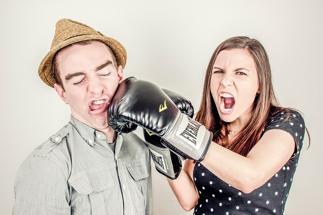 Image of a women in boxing gloves punching a man, used as a metaphor for conflict and conflict management