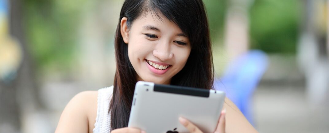 A young woman holding an ipad tablet