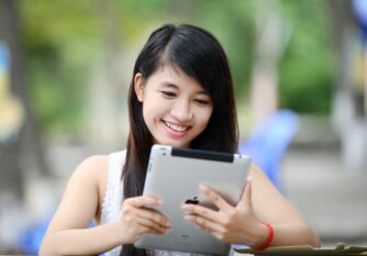 A young woman holding an ipad tablet